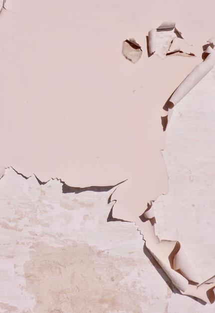 Peeling beige paint as background Wall loosing colour outside Damage due to strong sunlight