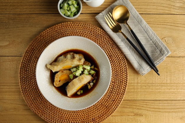 Pempek with cuko or vinegar sauce on white bowl