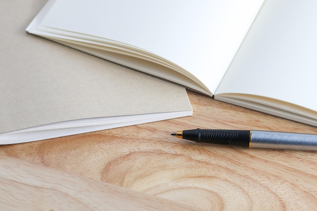 Pen and book on wood background