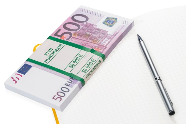 pen and a bundle of euro money on a clean notebook isolated on white background