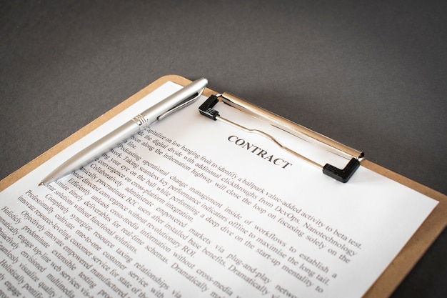 Pen and contract papers on wooden desk