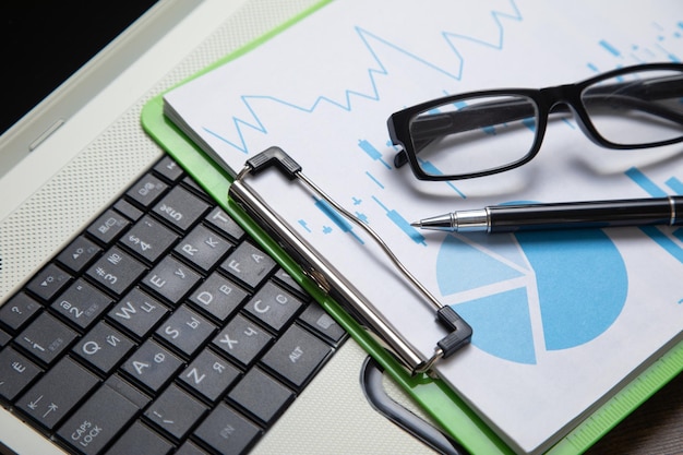 Pen eyeglasses graphs on the computer keyboard