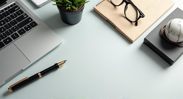 a pen and a notebook on a table with a plant in the background