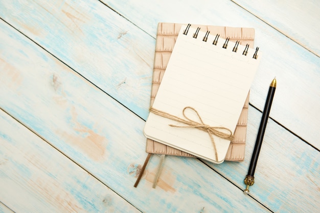 Pen and notebook up close on a rustic wooden desk