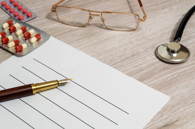 A pen on a sheet for writing a prescription to patient Working environment on the doctor's desk