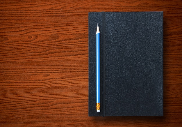 pencil with notebook on table background