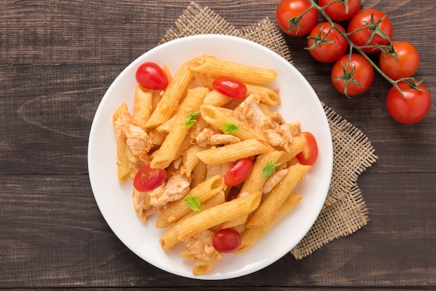 Penne pasta in tomato sauce with chicken on a wooden table