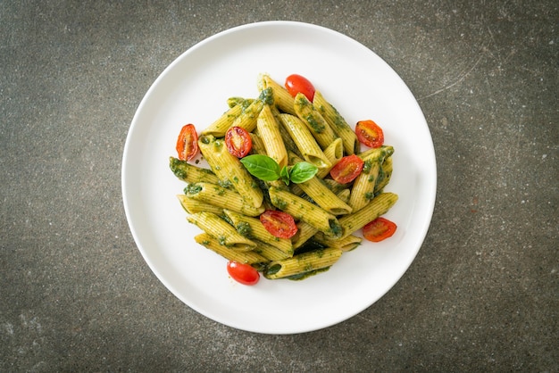 Penne pasta with pesto sauce and tomatoes