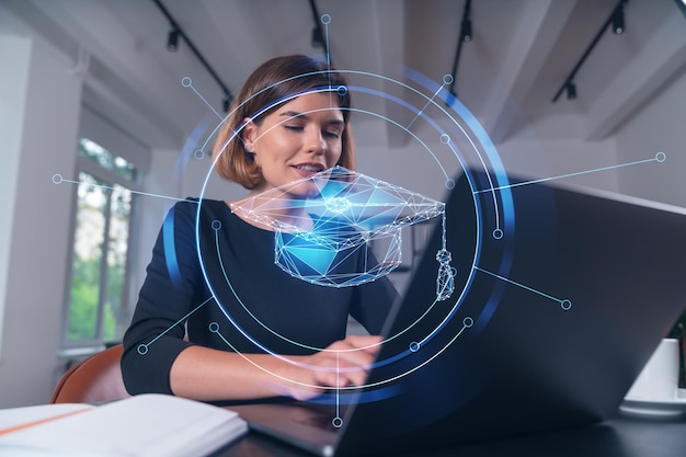 Pensive attractive beautiful businesswoman studying on laptop at university library in background Notebook table Concept of distant business education internet surfing information technology