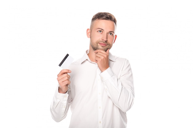 pensive businessman holding credit card isolated on white