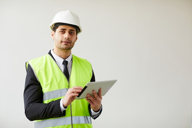 Pensive Engineer Holding Tablet