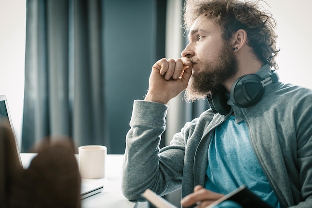 Pensive man is thinking how to organize his business process during the quarantine period a man is s...