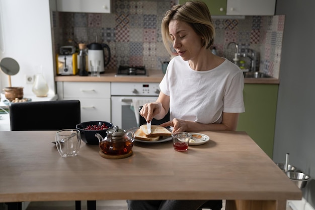 Pensive middleaged single woman enjoying healthy breakfast alone in peace and quiet