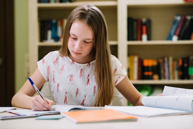 Pensive schoolgirl writing