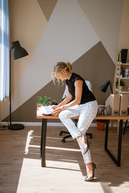 Pensive woman in office planning work schedule in notebook Sitting