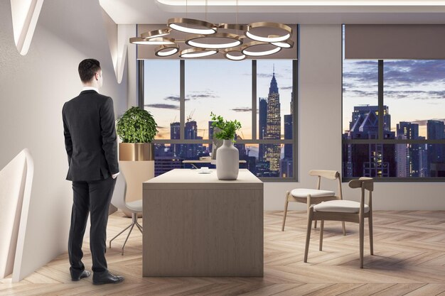 Pensive young european businessman standing in modern office interior Worker and CEO concept