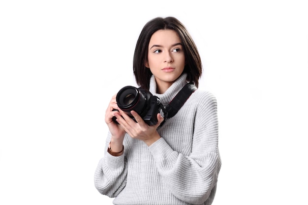 Pensive young pretty european girl photographer using modern camera looking thoughtfully