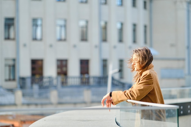 Pensive young woman at observation deck in a windy day