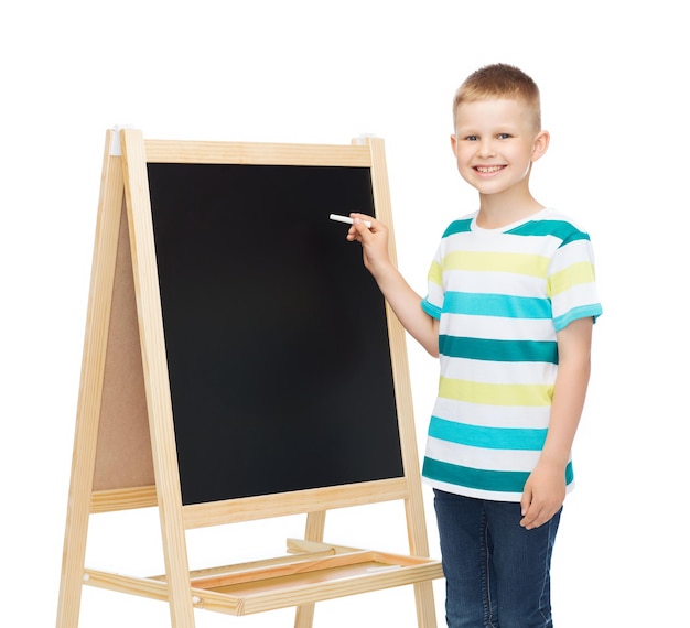 people, advertisement, childhood and education concept - happy little boy with blackboard and chalk