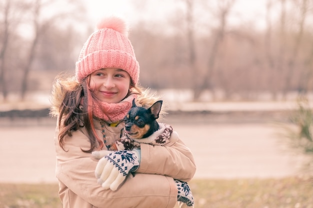 People and animals. Portrait of teenager girl. Teenage girl in a beige jacket in the park.