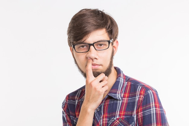 People, april fools day and gesture concept - young man picking his nose on white surface