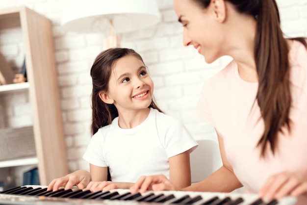 People are playing on piano and rest and have fun.