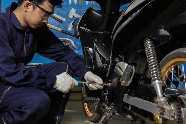 People are repairing a motorcycle Use a wrench and a screwdriver to work.