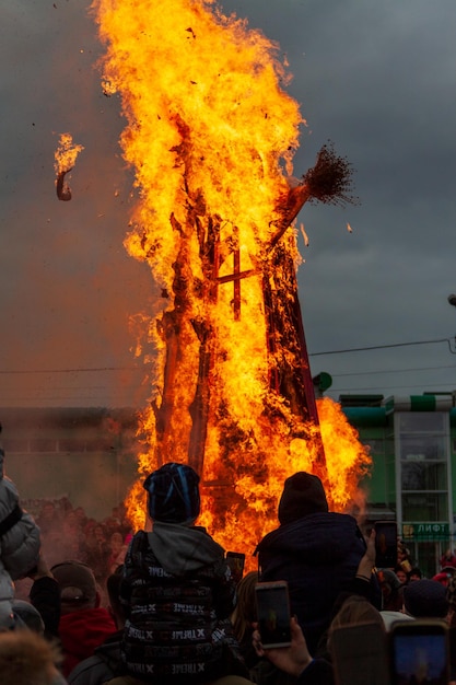 people are standing behind the fire, a burning effigy.