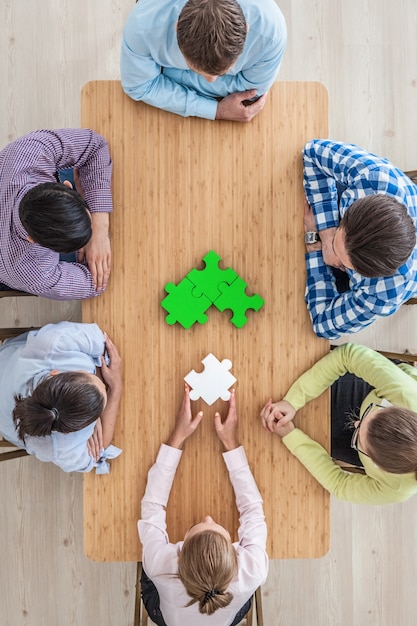 People assembling puzzle, corporate teamwork concept