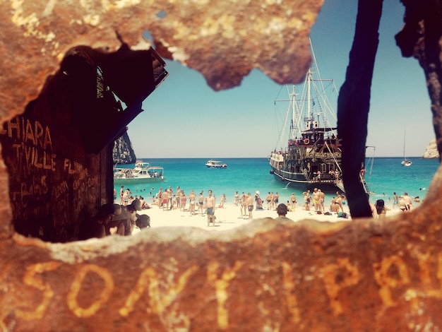 Photo people at beach seen through rock