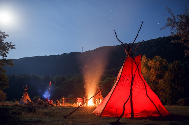 People camping in a forest at night