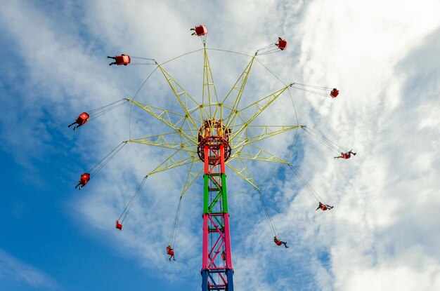 People on a carousel at a high altitude against the sky.