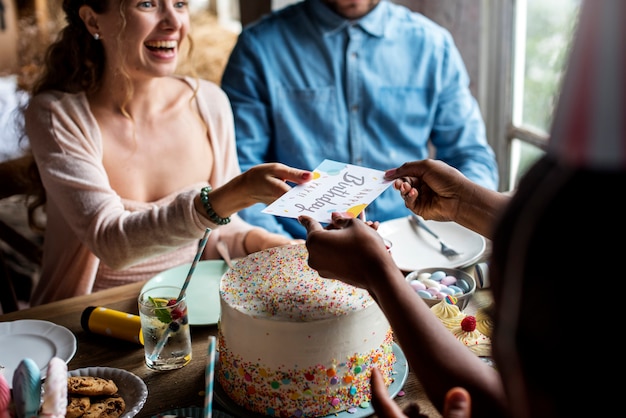 People celebrate birthday party with cake and card