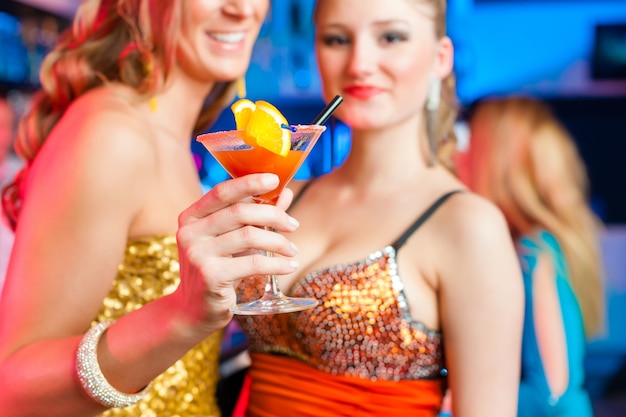 People in club or bar drinking cocktails