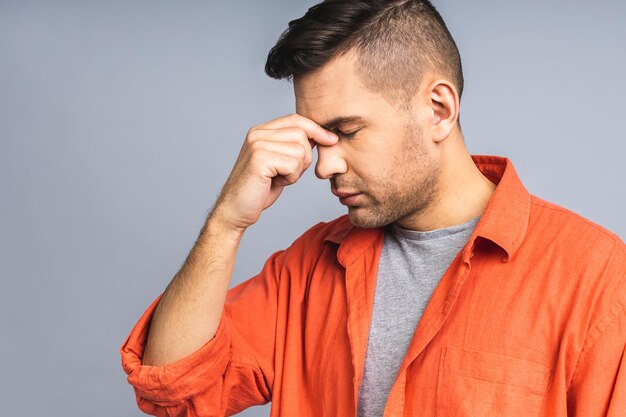 People crisis emotions and stress concept unhappy tired man suffering from head ache at home Isolated over grey white background