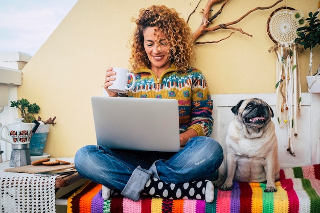 People and dog best friends forever together One happy woman smile and use laptop sitting near her lovely friend companion dog pug Animal and business lifestyle moment Modern leisure activity