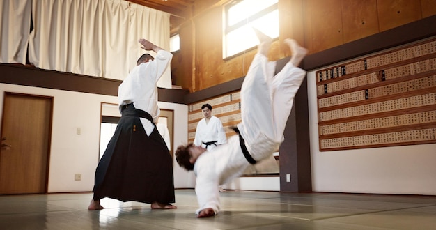 People dojo and sensei with student in self defense or training for fight or challenge with master Man teacher and martial arts class in Japan for practice lesson aikido or team battle in Tokyo