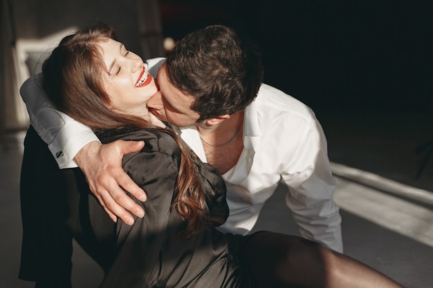 Photo people dressed in classic clothes. stylish couple in a sensual moment on white wall.