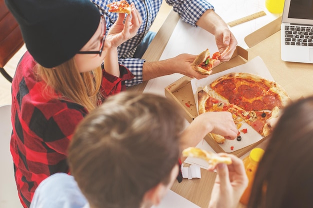 People eating pizza at workplace