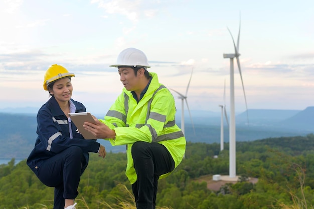 People engineer are wearing a protective helmet on head, using tablet Analytics engineering data.