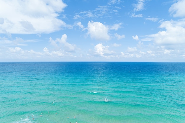 People enjoy swimming in tropical sea and wave crashing on sandy shore