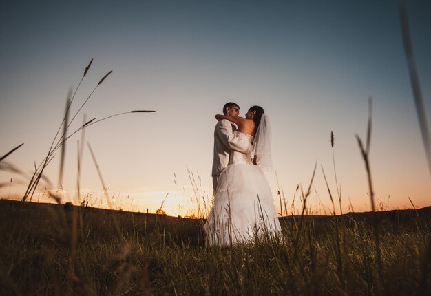 Photo people on field against sky during sunset