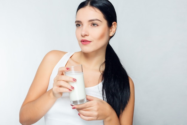 People, food, beauty, lifestyle, fashion and sensitive concept - Milk - Woman drinking milk, happy and smiling beautiful young woman enjoying a glass milk