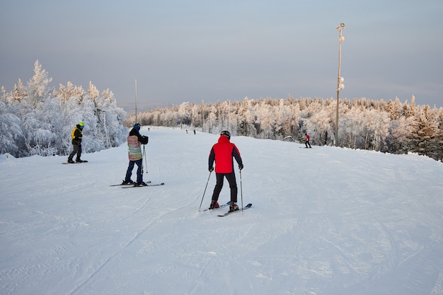 People go snowboarding and skiing, winter recreation and sports. Skiing down the mountain on a snowboard, funny emotions on the faces of men and women