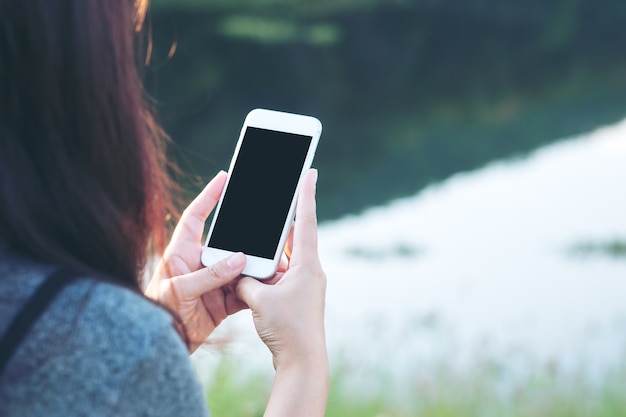 People hand using mockup smart phone at outdoor