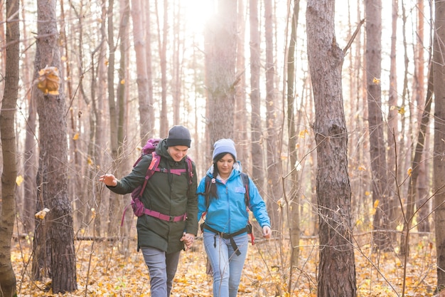 People, hike, tourism and nature concept - Couple tourist hiking in autumn forest.