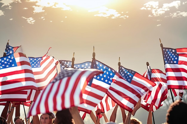 People holding american flags in front of a sunset