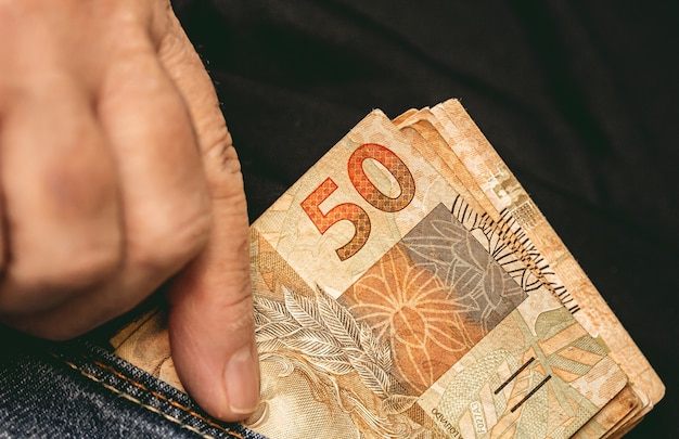 a people holding a brazilian banknotes of brazilian real