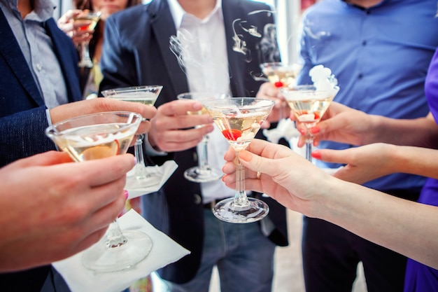 People holding glasses of champagne making a toast, hands with glasses