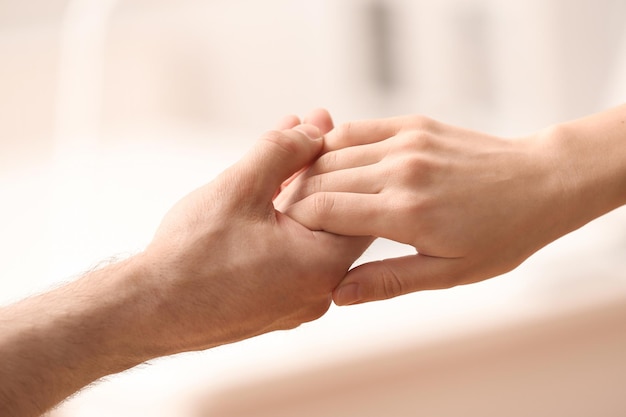 People holding hands against blurred background closeup